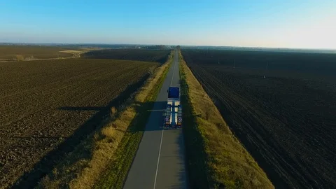Flying high above freight semi truck transporting goods on busy highway across Video stock 99804455