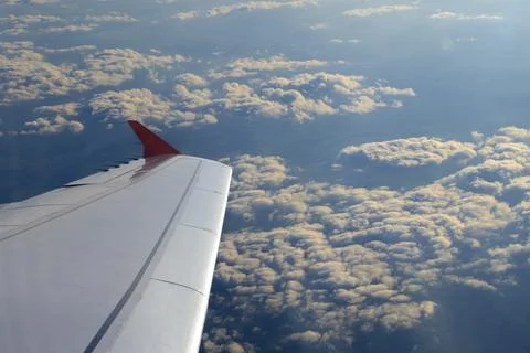Flying High: A View from the Cabin. Wing of an airplane flying above the cl.. Stock Photos