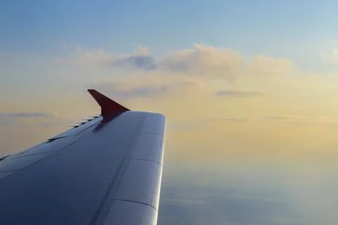 Flying High: A View from the Cabin. Wing of an airplane flying above the cl.. Stock Photos