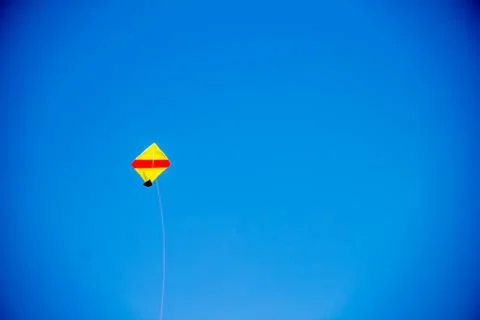 Flying kite in blue sky Stock Photos
