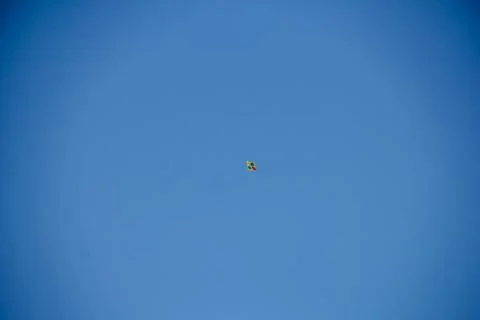 Flying kite in blue sky Stock Photos