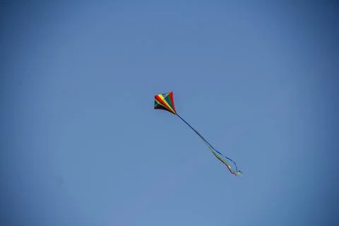 Flying kite in blue sky Stock Photos