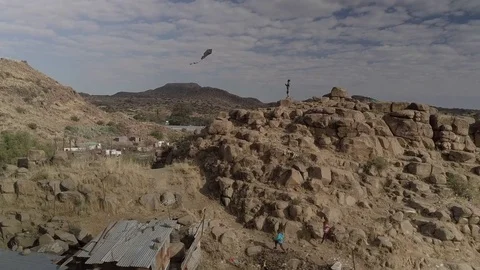 Flying a Kite from a Mountain Top Stock Footage 82629415