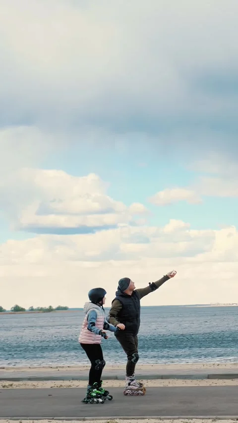 Flying kite. roller skating outdoors. Father and teenage daughter are flying a Stock Footage 316777889
