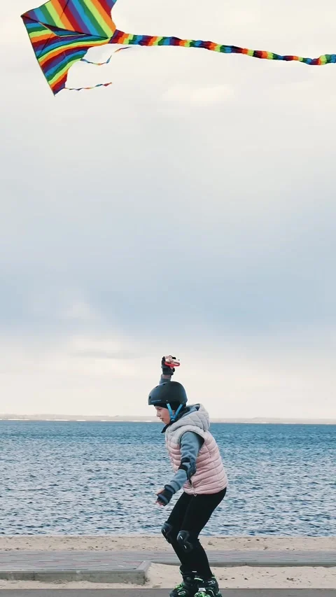 Flying kite. roller skating outdoors. teen girl is flying a kite, while Stock Footage 317164926