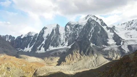 Flying to a large mountain range covered with glaciers and snow . Stockbeeldmateriaal 263732449