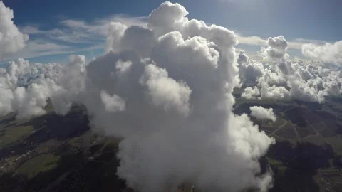 Flying up to large puffy cloud sun highlight Stock Footage 240492482