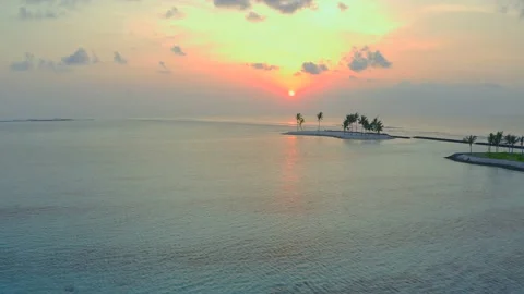 Flying left over the ocean Island with palm trees Yellow sunset Calm water N Stock Footage 220625904