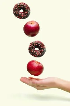 Flying levitating floating red ripe fresh apples with sweet glazed doughnut,d Stock Photos