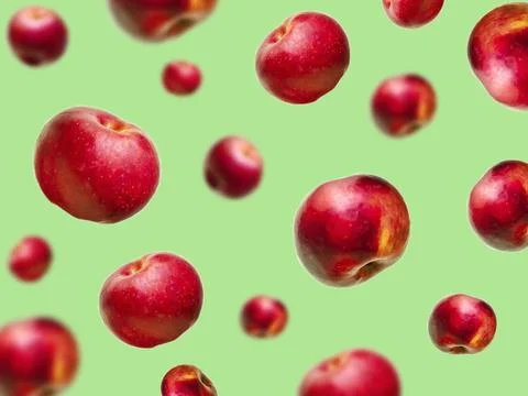 Flying levitating floating red ripe fresh juicy apples in air on green backgr Foto stock