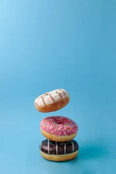 Flying levitating multicolored donuts on a blue background Foto stock