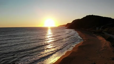 Flying low above the beach towards the sunset. Stock Footage 130662339