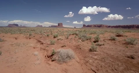 Flying low and fast over the desert sagebrush of Monument Valley Stock Footage 111373749
