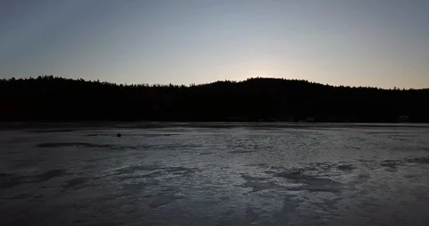 Flying low and fast over a dark frozen lake Video stock 122398225