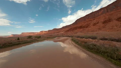 Flying low and fast over chocolate, mirrored river in the desert Stock Footage 165027237