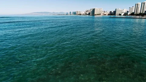 Flying low and turning right over the clear blue water with a view along Video stock 109454757