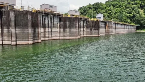 Flying low level along and away Bayano Dam with Hydroelectric Power Plant Stock Footage 318510968