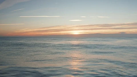 Flying low over the beach and ocean at sunrise Stockbeeldmateriaal 100410876