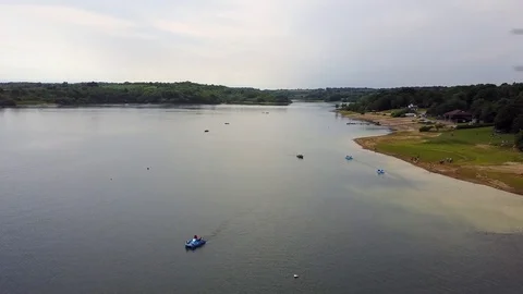 Flying low over Bewl Water lake in Lamberhurst, East Sussex Stock Footage 77074192