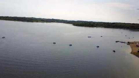 Flying low over Bewl Water reservoir lake in Lamberhurst, East Sussex Stock Footage 77074378