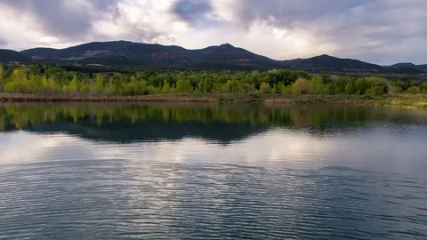 Flying low over a calm mountain lake at sunset Stock Footage 81934447
