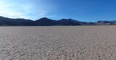 Flying low over cracked desert Racetrack Playa in Death Valley NP Stock Footage 72969647
