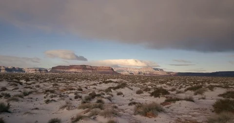 Flying low over the desert and sagebrush of Monument Valley with fresh snow Stock Footage 106482771