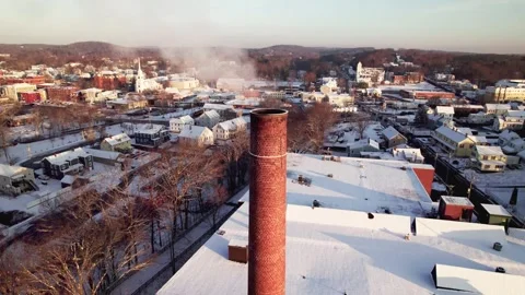 Flying low over a large smoke stack with white vapor rising from it. Snow Stock Footage 316802823