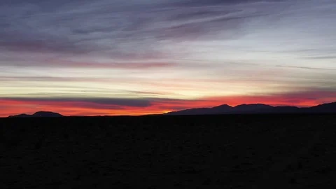 Flying low over Mojave Desert at night with bright pink sunset sky Stock Footage 101970924