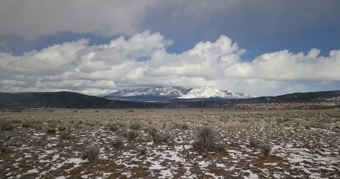 Flying low over the prairie toward snowy mountain peaks Stock Footage 107107166