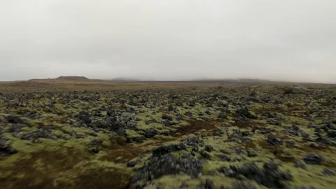 Flying low over rocky volcanic lava field covered by green moss in Iceland Video stock 149043675