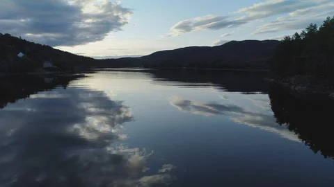 Flying low over the surface of a calm peaceful lake in the countryside Stock Footage 113340142