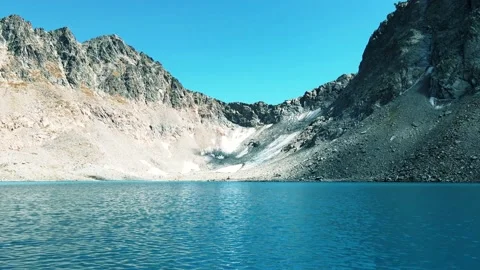 Flying low over the water of a mountain lake with blue water Stock Footage 138442955