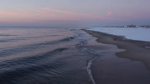 Flying low over the waves crashing at sunrise Stock Footage 105550792