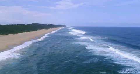 Flying low over the waves lapping on deserted beach in Indian Ocean aerial 4K Stock Footage 87573849