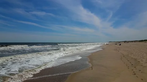 Flying a Mavic air 2 drone over a beach on a sunny Day of May Stock Footage 130589106