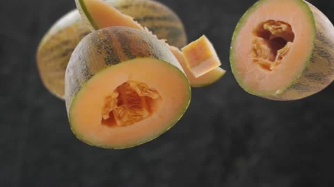 Flying Melon and Melons slices in Dark Kitchen Background Stock Footage 229560900