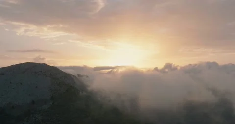 Flying in mountainous terrain at cloud level at sunset. Spain Stock Footage 220737215