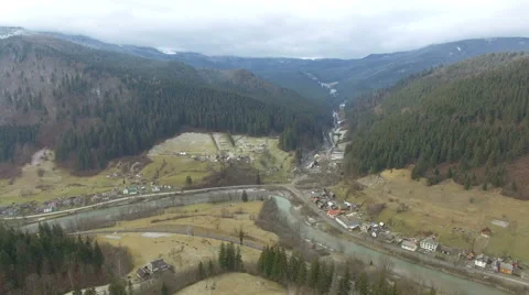 Flying in the mountains above the pine forest and the river Stock Footage 59780656