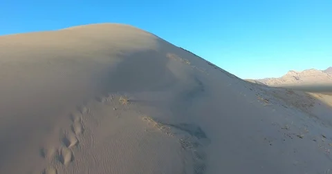Flying up the Mt. Kelso sand dune ridge in Mojave National Preserve at sunset Stock Footage 73529072