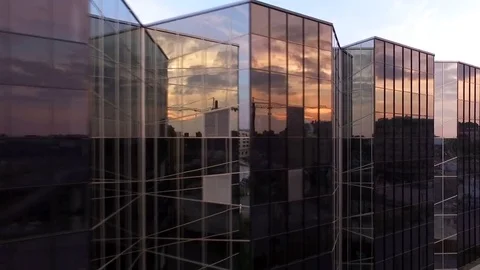 Flying near the mirrored windows of an office building. Sunset. Stock Footage 72667397
