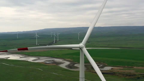 Flying next to the rotating blades of a windmill. Stock Footage 229769594