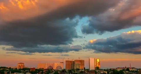 Flying orange clouds at sunset over the town landscape Stock Footage 138444447