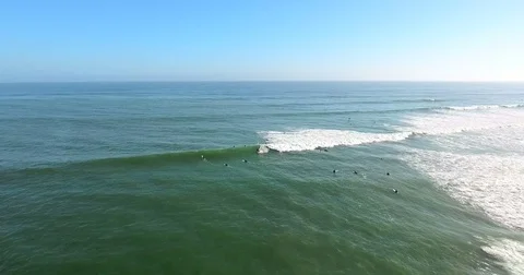 Flying out over surfers at C Street surf spot in Ventura, California Stock Footage 73099420