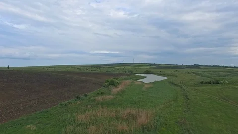 Flying over agricultural fields and small lake Stock Footage 99071724
