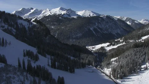 Flying over an alpine valley closing in on a small village Vídeos de archivo 101896145