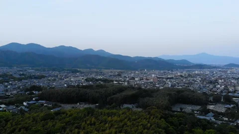 Flying over bamboo forest, overlooking the rural city, shrines and mountains Stock Footage 111888701