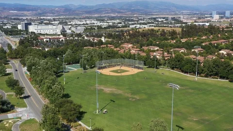 Flying over a baseball field with a little leaguge game going on. Video stock 108760217