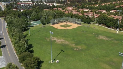 Flying over a baseball field with a little leaguge game going on Stock Footage 108760287