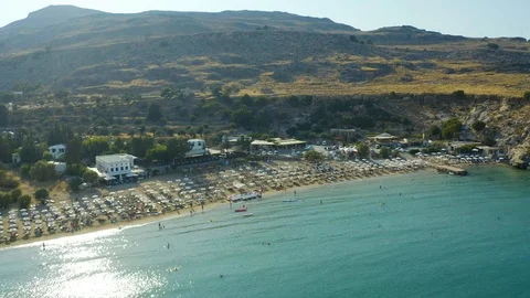 Flying over the beach in Bay with a sandy shore, Greece, sunset, people swim and Stock Footage 116909575